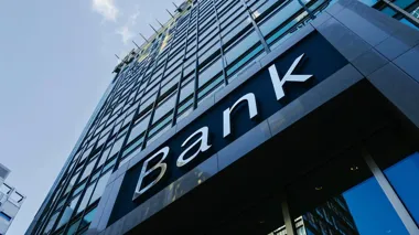 Fasada nowoczesnego biurowca z dużym napisem „Bank”.