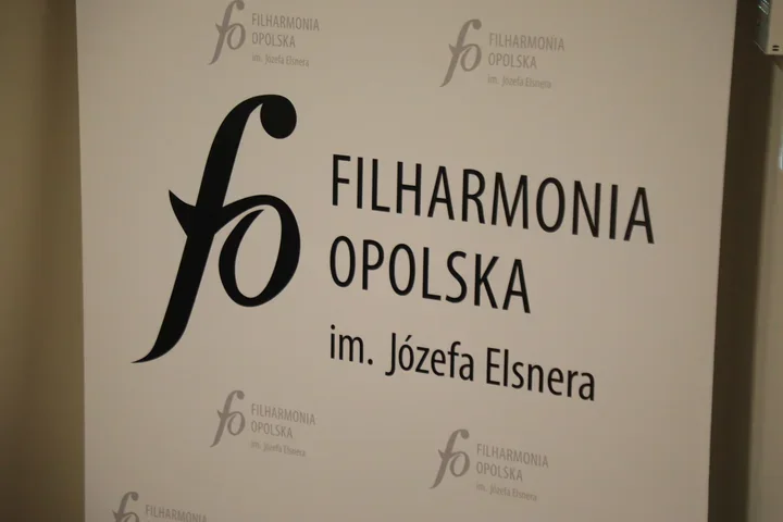 Fragment roll-upu z logo i nazwą Filharmonii Opolskiej im. Józefa Elsnera.