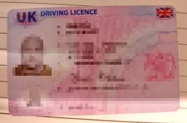 Zbliżenie na brytyjskie prawo jazdy z zamazanymi danymi osobowymi.