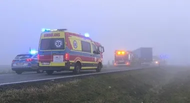 Pogotowie ratunkowe, policja i straż pożarna interweniują na mglistej drodze w pobliżu ciężarówki.